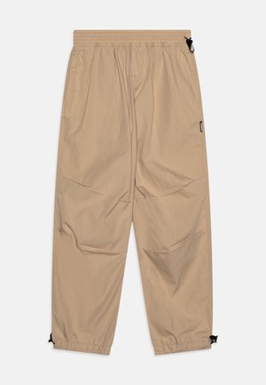 Beige leichte Hose aus glattem Stoff, mit Gummizugbund, seitlichen Taschen und verstellbaren Säumen mit schwarzen Kordelzügen.