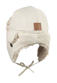 Cremefarvet vintertrapperhat med faux fur-for, øreklapper, kinbånd og et brunt rektangulært logo-patch på forsiden.