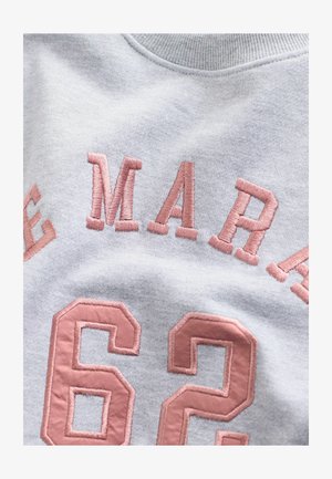 Gray sweatshirt with pink embroidered text. Features "62" and "MAR" in bold letters. Soft texture with a round neckline and ribbed collar.