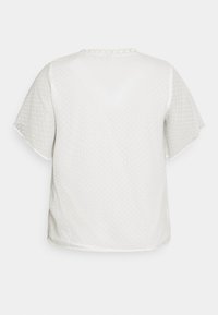 Lettet hvid bluse med korte ærmer, struktureret polka dot mønster, rund halsudskæring og delikat kant på bagsiden.