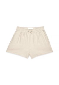 Beige linen shorts with an elastic waistband, drawstring tie, and side pockets. Features a smooth texture and relaxed fit.