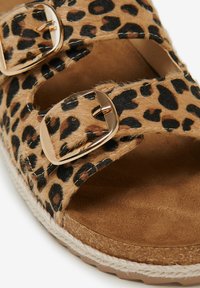 Sandali con stampa leopardata caratterizzati da una texture in pelliccia marrone, due fibbie dorate regolabili e una soletta beige con una suola avvolta in juta.