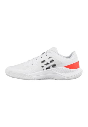 Weißer Sportschuh mit schwarzen Streifen an der Seite und einem hellroten Fersenakzent, strukturierte Sohle und Schnürdesign, von der Seite gezeigt.