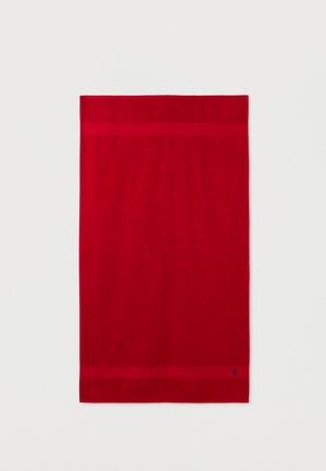Serviette de bain rectangulaire rouge avec une bordure tissée subtile près des bords supérieur et inférieur, sur un fond blanc uni.