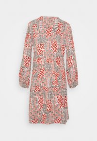 Vícebarevné šaty s patchworkem geometrických vzorů v červené, černé a krémové barvě. Dlouhé rukávy s nařasenými manžetami a kulatým výstřihem.