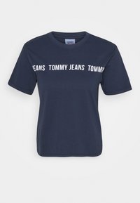 Camiseta de manga corta azul marino con cuello redondo y texto en blanco "TOMMY JEANS" repetido horizontalmente en el pecho.
