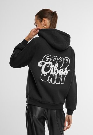 Black hoodie with a large white text design on the back that reads "GOOD VIBES ONLY." Features a drawstring hood and ribbed cuffs.