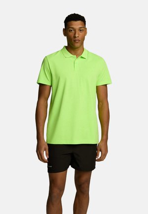 Neonowa zielona koszulka polo z kołnierzykiem i krótkimi rękawami, wykonana z gładkiego, lekkiego materiału, zestawiona z czarnymi szortami.