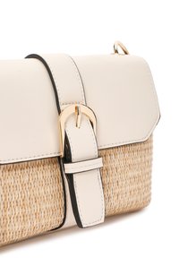 Beige handtas met een strobody en een gladde witte leren flap. Gouden gespdetails op de schouderband, met zwarte randaccenten.