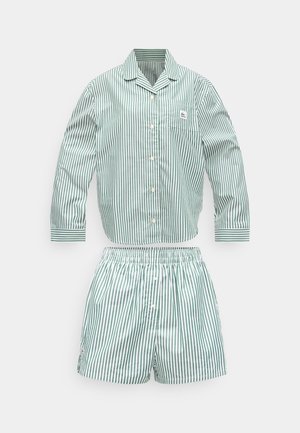 Zaļi baltas svītras, garām piedurknēm pogājams pidžamas krekls ar krūšu kabatu un atbilstošas šorti ar elastīgu vidukli.