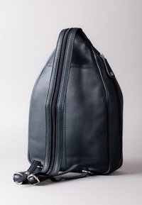 Dark navy leather backpack with a triangular shape, featuring two zippers along the side, and adjustable straps for carrying.