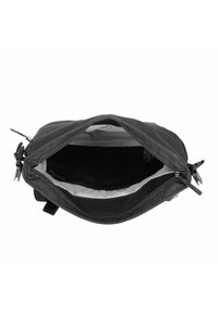 Bolsa de lona negra con una abertura ancha, con un interior claro, bolsillo con cremallera y dos tiradores de cremallera laterales. Material duradero y diseño simple.