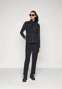 Herreutendørsklær med en navy softshellvest med glidelåslommer og matchende navy bukser, kombinert med svarte tursko.