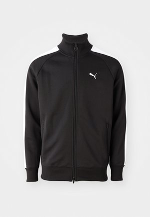 Veste de sport noire zippée avec des bandes blanches sur les manches, col et poignets côtelés, et logo Puma blanc sur la poitrine gauche.