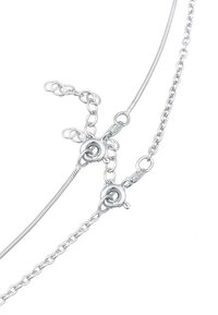 Collana in argento caratterizzata da un design liscio e elegante con un gancio e catene aggiuntive per la regolazione della lunghezza.