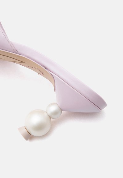 Πέδιλο με ψηλό τακούνι σε απαλό λιλά χρώμα με μοναδικό τακούνι που αποτελείται από δύο λευκές σφαίρες που μοιάζουν με μαργαριτάρια στοιβαγμένες κάθετα.