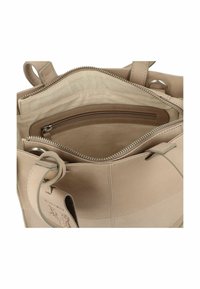 Bolso de cuero beige con cierre de cremallera. El interior cuenta con un compartimento grande y un bolsillo pequeño con cremallera, textura suave y costuras mínimas.