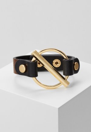 Sort læderarmbånd med en gylden cirkulær lukning med en struktureret vandret stang og gyldne trykknapper på remmen.