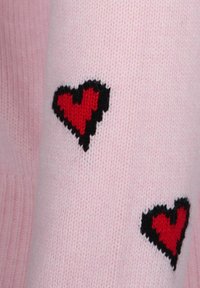 Maglione rosa lavorato a maglia con motivi a cuore neri e rossi. Texture morbida con accenti a contrasto e polsini a coste.