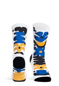 Calze alte fino al ginocchio di colore bianco con motivi floreali astratti in blu, giallo e nero. Presentano una punta rinforzata nera e una trama a coste.
