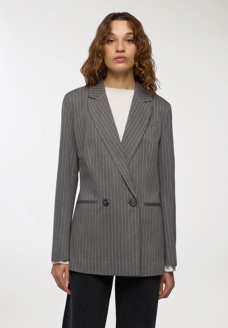 Szary żakiet w paski z podwójnym zapięciem, klapami połówkowymi, dwiema przednimi kieszeniami oraz czarnymi guzikami. Gładka faktura i dopasowany krój.