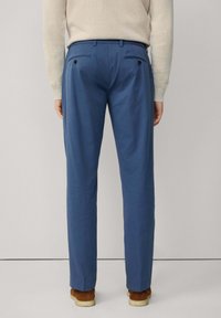 Pantalones de mezcla de algodón azul con corte recto, que cuentan con dos bolsillos traseros y una textura suave, combinados con zapatos marrones.