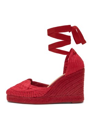 Červená klinová espadrilka s prepleteným detailom, uzavretou špičkou a remienkami viazanými okolo členku, navrhnutá pre dámsku módu.