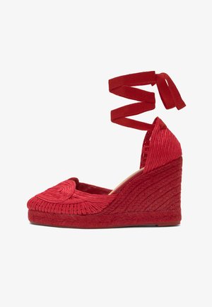 Espadrille rouge en forme de coin avec détails tissés, bout fermé et brides à nouer autour de la cheville, conçue pour la mode féminine.