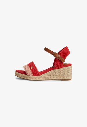 Sandale compensée tissée rouge et rose avec bride de cheville beige et semelle en jute tressée, vue de côté sur fond blanc.