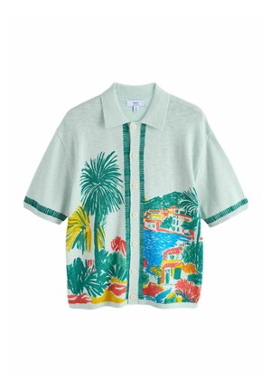 Short-sleeve button-up shirt with collar, featuring colorful tropical landscape print of palm trees, water, and buildings on light green fabric.