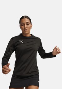 Maglietta sportiva nera a maniche lunghe realizzata in tessuto morbido, con scollatura rotonda e logo Puma bianco sul petto.