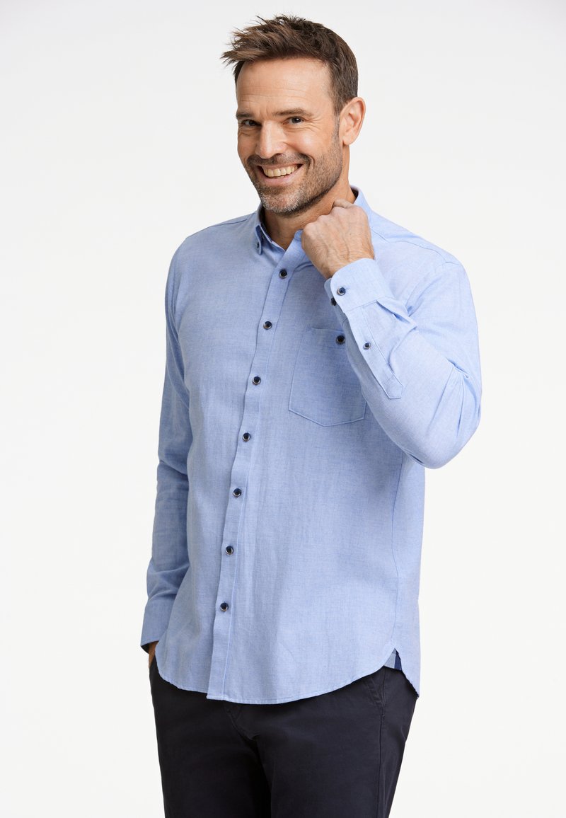 Ljusblå knapp-up skjorta med långärmar och mörka knappar, med en bröstficka och rundad nederkant. Slät, strukturerad tyg.