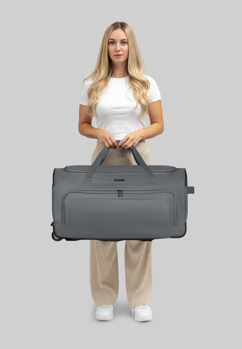 Grau Reisetasche, aus robustem Material, verfügt über zwei obere Griffe, Reißverschlussfächer und einen verstärkten Boden. Maße nicht angegeben.