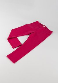 Fuchsia Leggings liegen flach auf einem hellgrauen Hintergrund, mit einem Bund und einem kleinen Logo auf der Oberseite.