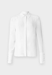 Blusa blanca de manga larga con cuello clásico, cierre de botones en la parte delantera y detalle de cinco botones en los puños; tejido suave y ajuste entallado.