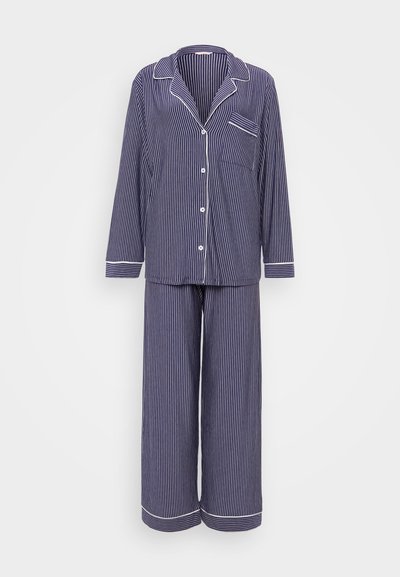 Navy and white striped pajama set featuring a button-down top with a pocket and long pants with wide legs and cuffs. Cotton material.