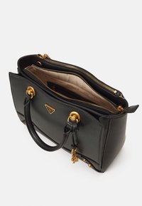 Sac à main en cuir noir avec quincaillerie dorée, doubles zips et logo triangulaire. L'intérieur présente une doublure en tissu clair avec des accents en motif.