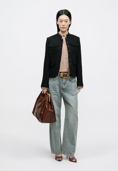 Sort kort jakke med knaplukning, stribet skjorte, lyseblå løse jeans, brun lædertaske og åbne høje hæle sandaler.