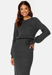 Graues, geripptes Strickkleid mit langen Ärmeln und gebundenem Taillendetail, das eine figurbetonte Silhouette und eine strukturierte Stoffqualität bietet.