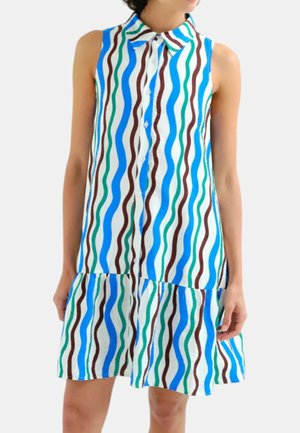 Vestito senza maniche con collo e bottoni sul davanti, con righe verticali ondulate blu, verdi, marroni e bianche, indossato da una persona su sfondo neutro.
