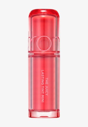Mini læbestift med rødlig nuance og gennemsigtig hætte, mærket "The Juicy Lasting Tint Mini" lodret på siden.