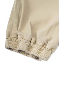 Khakifarbene Jogginghosen mit elastischem Bündchen am Saum und strukturiertem Detail. Das glatte, leichte Material sorgt für eine lässige Passform.