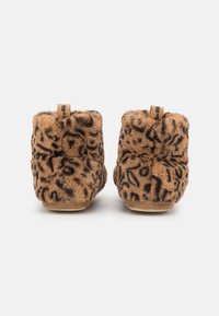 Brown faux-fur slippers with a leopard print design, short ankle height, and smooth soles; featuring a looped fabric tag on the back.
