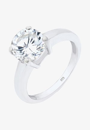 Bague en argent avec une large pierre précieuse ronde et transparente sertie dans un support à quatre griffes ; design de bande lisse ; gravée avec "925" indiquant la teneur en argent.