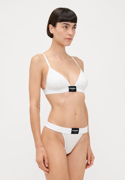 Set bikini bianco composto da un reggiseno a triangolo con spalline regolabili e banda con logo; perizoma a vita bassa coordinato con una banda simile.