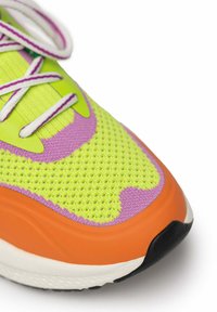 Neon green sneaker featuring a textured mesh upper, purple accents, an orange midsole, and white laces, with a black rubber outsole.