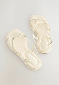 Sandali bianchi in satin con punta quadrata, sottili cinturini traslucidi e una fascia decorata con strass sopra il piede per un tocco di dettaglio in più.