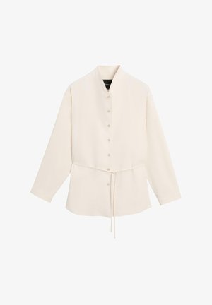 Cream long-sleeve button-up shirt with a high collar and adjustable drawstring waist, displayed on a plain white background.