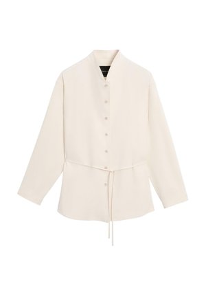 Cream long-sleeve button-up shirt with a high collar and adjustable drawstring waist, displayed on a plain white background.
