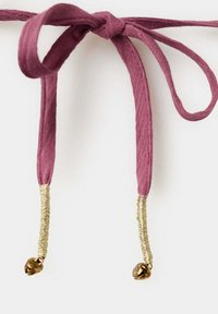 Cordon en tissu rose foncé noué en nœud avec un fil d’or enroulé près des extrémités et de petites clochettes dorées attachées à chaque extrémité.